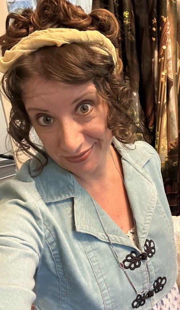 Annette in a light blue period-inspired jacket with curls