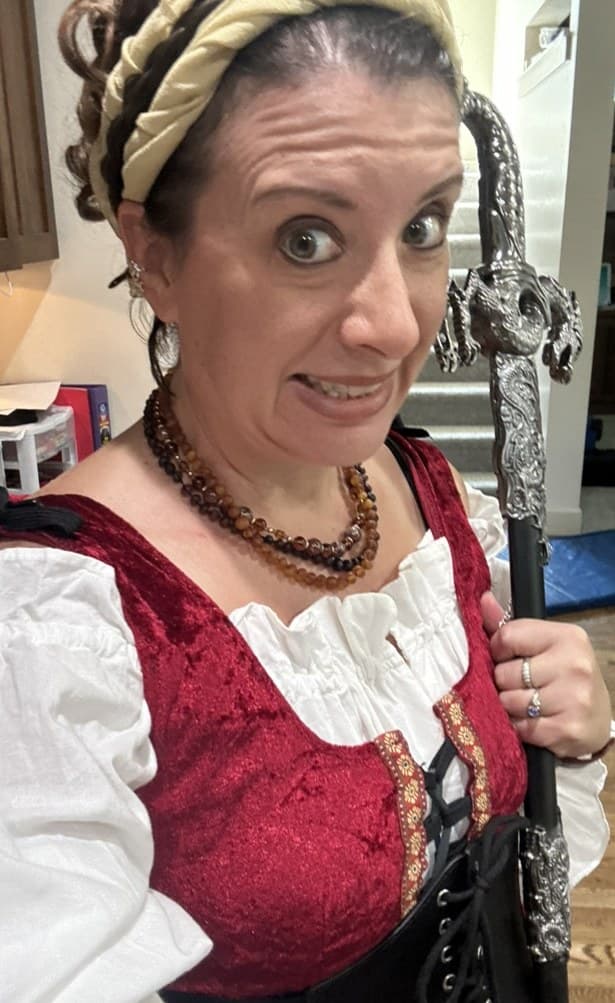 Annette in a red velvet costume holding a prop sword