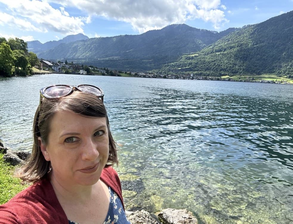 Annette outdoors by a lake on a travel day
